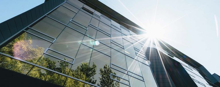 Large glass building with reflection of the sun