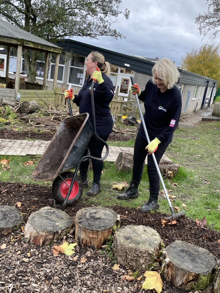 Image shows 2 women working in a community garden