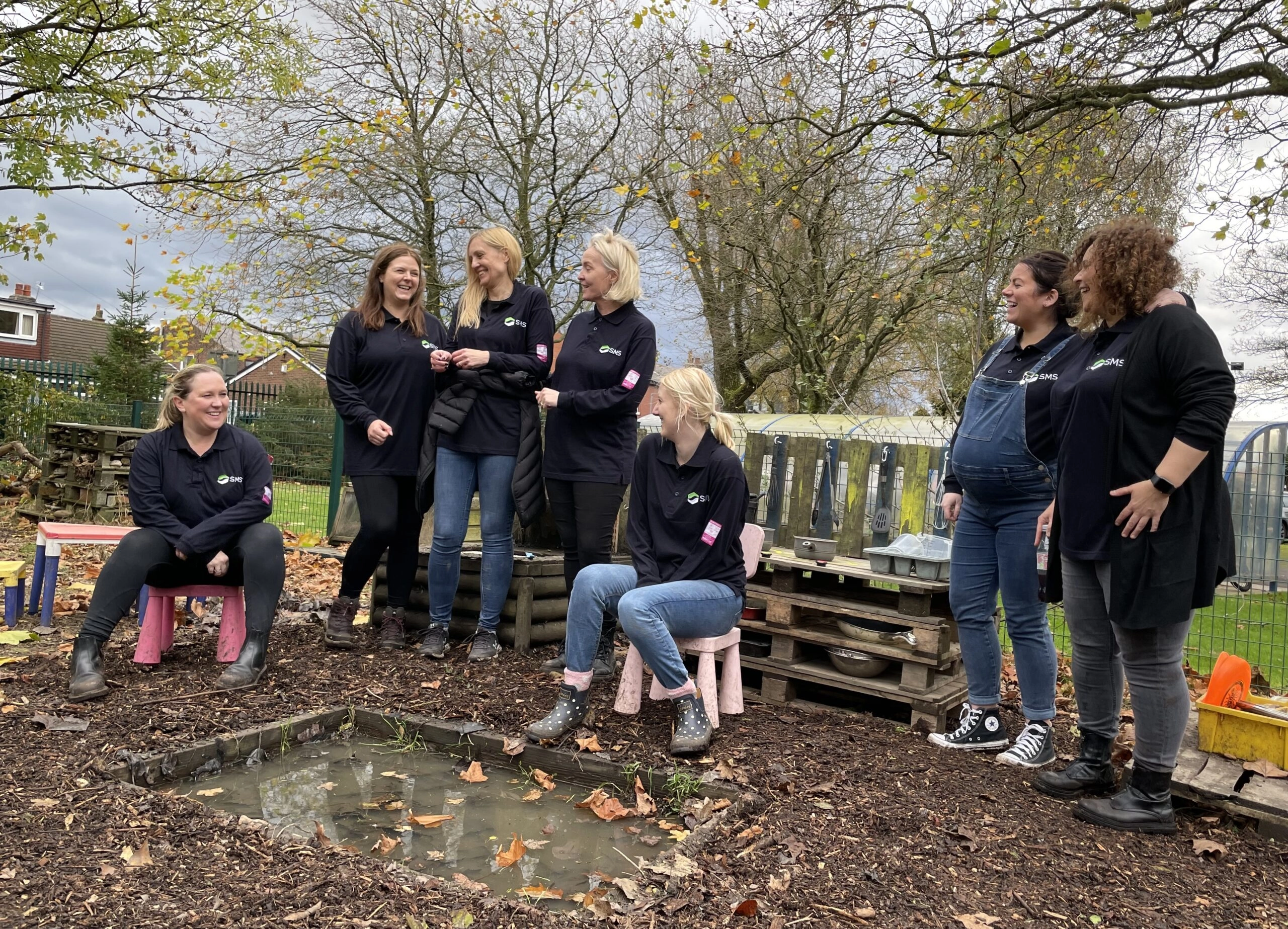 Image showing a group of workers standing in a community garden after work