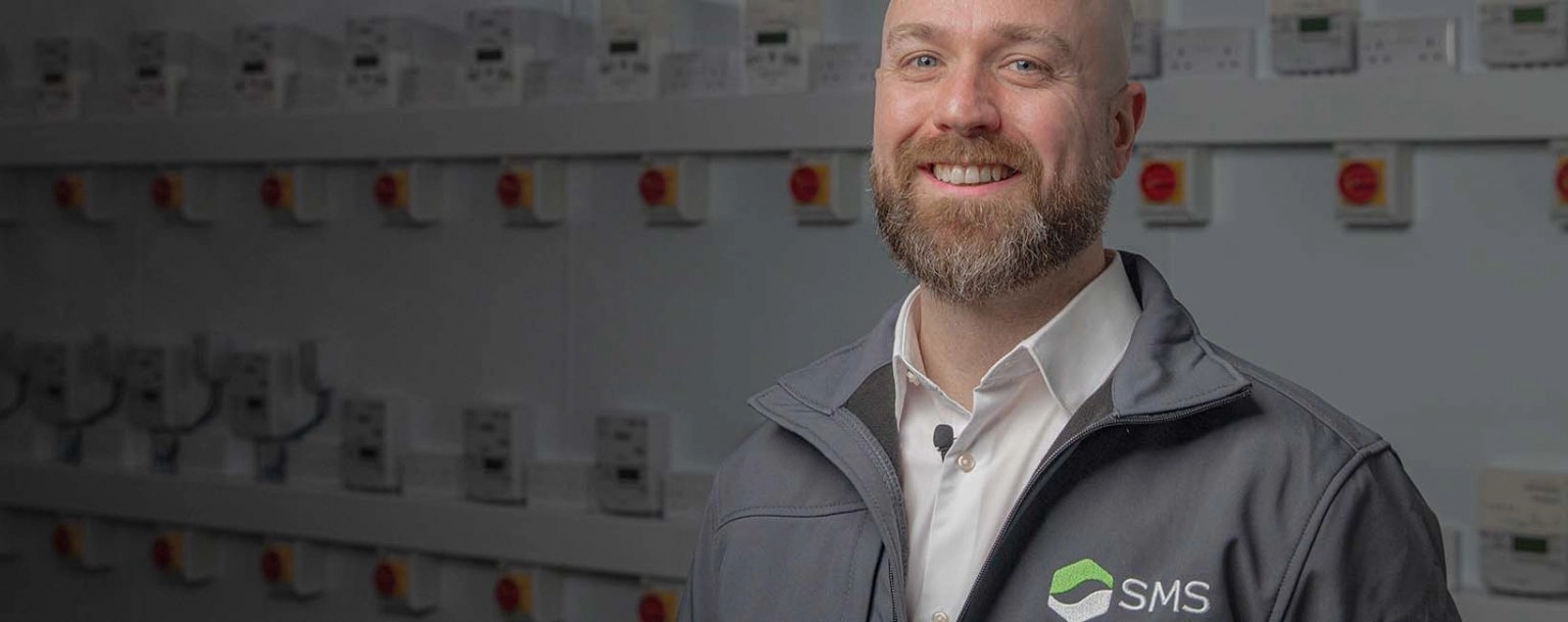 SMS engineer in front of large scale sub metering setup
